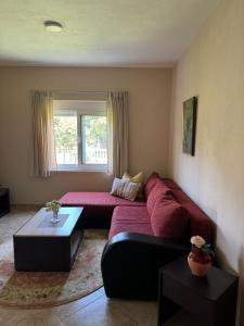 a living room with a red couch and a window at Sunrise house apartments in Ulcinj