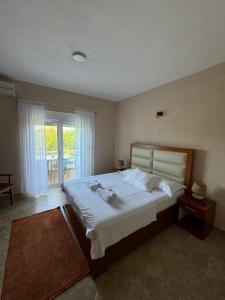 a bedroom with a large bed and a balcony at Sunrise house apartments in Ulcinj