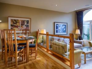 Un comedor y una sala de estar con mesa y sillas. en Underscar - Grange, en Keswick