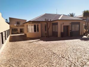 a house with a cobblestone driveway in front of it at Grace on 51York Lodge in Johannesburg