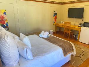 a bedroom with a bed with white pillows and a desk at Grace on 51York Lodge in Johannesburg
