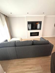 a living room with a couch and a flat screen tv at Piso Playa de Los Barcos in Isla +15 photos