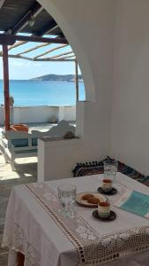 a table with a white table cloth with a view of the ocean at Styfilia Beachfront Apartments in Platis Yialos Sifnos