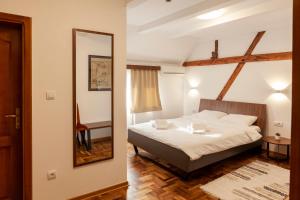 a bedroom with a bed and a mirror at Prenoćište Omega Luxury in Čačak