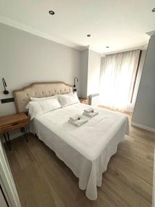 a bedroom with a large white bed with white sheets at Piso Playa de Los Barcos in Isla