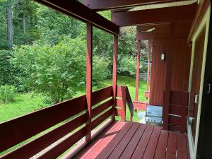 a screened porch of a cabin with a view of the woods at Das Rote Haus am See in Kochel