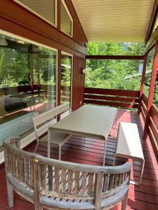 a porch with a table and a bench on it at Das Rote Haus am See in Kochel