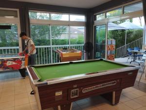 a man standing in a room with a pool table at Harmonie in Calvisson