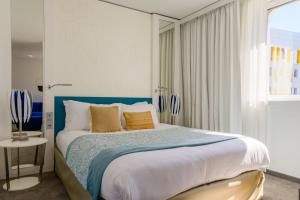 a bedroom with a large bed with a blue headboard at Golden Tulip Marseille Euromed in Marseille