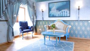 a living room with a couch and a table and two chairs at Hotel & Tagungszentrum Schloss Hohenfels in Hohenfels