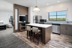 a kitchen with a kitchen island and a living room at Hyatt House Naples 5th Avenue in Naples