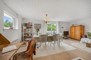 Una sala de estar con mesa de comedor y sillas. en Cozy Holiday Home, Located In The Peaceful Area Of Klegod - 1038, en Ringkøbing
