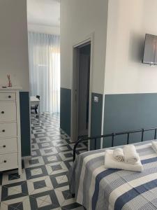 a bedroom with a bed and a dresser with towels on it at DONNA MARIA in Sapri +12 photos
