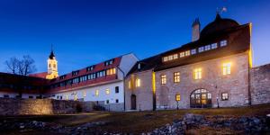 PécsváradにあるIstván Király Szállóの時計塔を背景にした古い建物