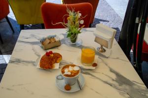 a table with a cup of coffee and a plate of food at Aiello Hotels - Duomo in Milan