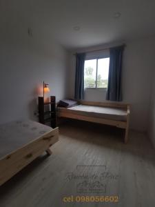 a bedroom with two beds and a window at Rincón de paz in Villa Serrana +44 photos