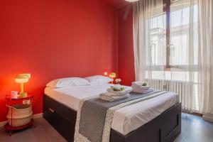 a bedroom with red walls and a bed with towels on it at Urban House - 301 in Monza