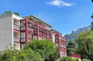 un condominio rosso con le montagne sullo sfondo di UFO´s Holiday Resort a Bad Reichenhall