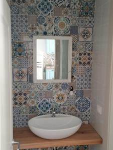a bathroom with a sink and a mirror and tiles at Il Rosmarino in Marciana
