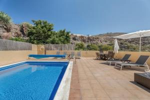 ギア・デ・イソラにあるFinca Edénの椅子とパラソルのあるプール