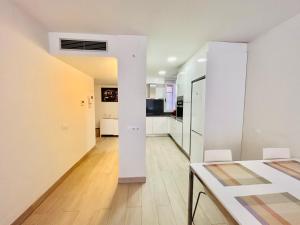 a kitchen and dining room with white walls and a table at Apartamento Rambla Vella in Tarragona