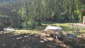 a table and chairs in a yard with a swing at Chalet chez l'habitant in Barbentane