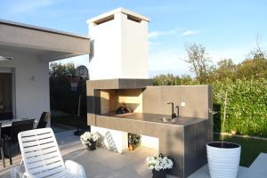 a outdoor kitchen with a fireplace on a patio at Holiday Home Maslina in Široki Brijeg