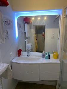 ein Badezimmer mit einem weißen Waschbecken und einem Spiegel in der Unterkunft Superbe appartement digue vue mer in Knokke-Heist