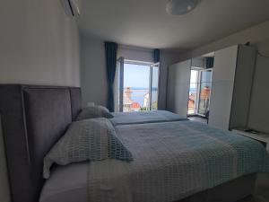 a bedroom with a bed with a view of the ocean at Apartments Elizabeta in Dramalj