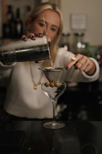 a woman pouring a drink into a martini glass at Drakes Hotel in Brighton & Hove