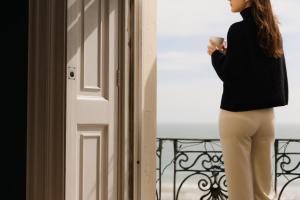 a woman standing next to a door holding a cup at Drakes Hotel in Brighton & Hove