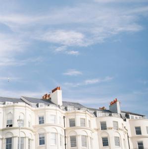a white building with a blue sky in the background at Drakes Hotel in Brighton & Hove