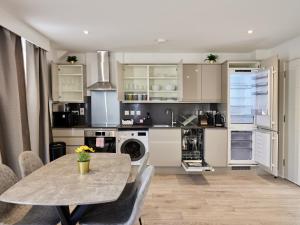 een keuken met een tafel en een eetkamer bij Hampton Suites Serviced Apartments in Kingston upon Thames +22 foto's