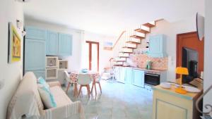a kitchen and dining room with blue cabinets and a table at Appartamento La Terrazza - Località Cala Gavetta in La Maddalena