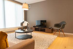 a living room with a couch and two chairs and a television at Snow Monkey Loft in Kutchan