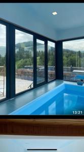 a swimming pool in a house with windows at BM Plaza in Bakuriani