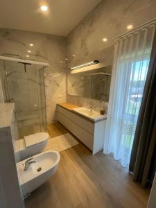 a bathroom with a sink and a toilet and a tub at Kotedzas Sventojoje 11 Gulbiu in Šventoji