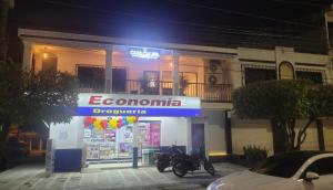 a motorcycle parked in front of a store at night at Casa Calina Hotel in Caucasia