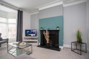 a living room with a fireplace and a tv at The Imeary - Vacant Nests in Westoe