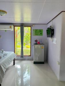 ein Krankenhauszimmer mit einem Bett und einem Fenster in der Unterkunft รรินธารา รีสอร์ท in Ban Bang Khan