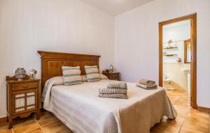 ein Schlafzimmer mit einem großen Bett mit einem hölzernen Kopfteil in der Unterkunft Nice Home In Chiclana De La Fronter in Chiclana de la Frontera + 20 Fotos