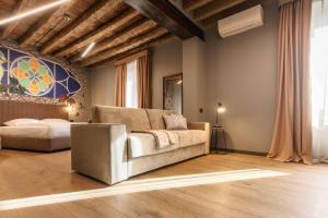 un soggiorno con divano e letto di AR Suites&Art a Bergamo Altre 37 foto