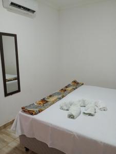 a bed with a white table with a mirror at Mariana Chale in São Miguel do Gostoso +8 photos