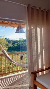 Un dormitorio con una ventana con vista a una terraza. en Villa apartamentos, en Trancoso