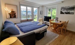a bedroom with a bed and a table and a desk at Haus Bodmen C, Apartment Grünsee in Zermatt