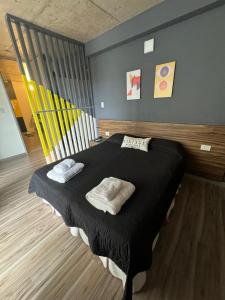 a bedroom with a black bed with two pillows on it at BEM Apartamento in Salta