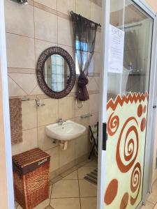 un bagno con lavandino e specchio di The blue room a Phalaborwa