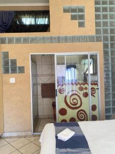 doccia con porta in vetro in camera di The blue room a Phalaborwa