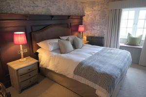 a bedroom with a bed with two lamps on a night stand at The Falcon Inn in Scarborough +2 photos