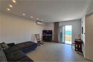 a living room with a couch and a television at Apartment Capitano in Slatine